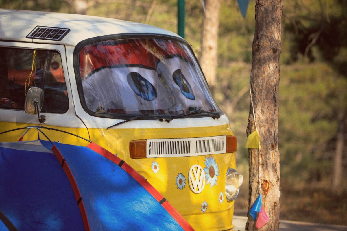 Bright campervan and tent set up in a wooded area, perfect for an outdoor adventure.