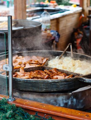 Close-up of traditional street food being cooked outdoors at a market in Poznań, Poland.