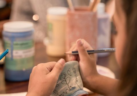 Children painting ceramics in a pottery workshop, enjoying creativity and bonding.